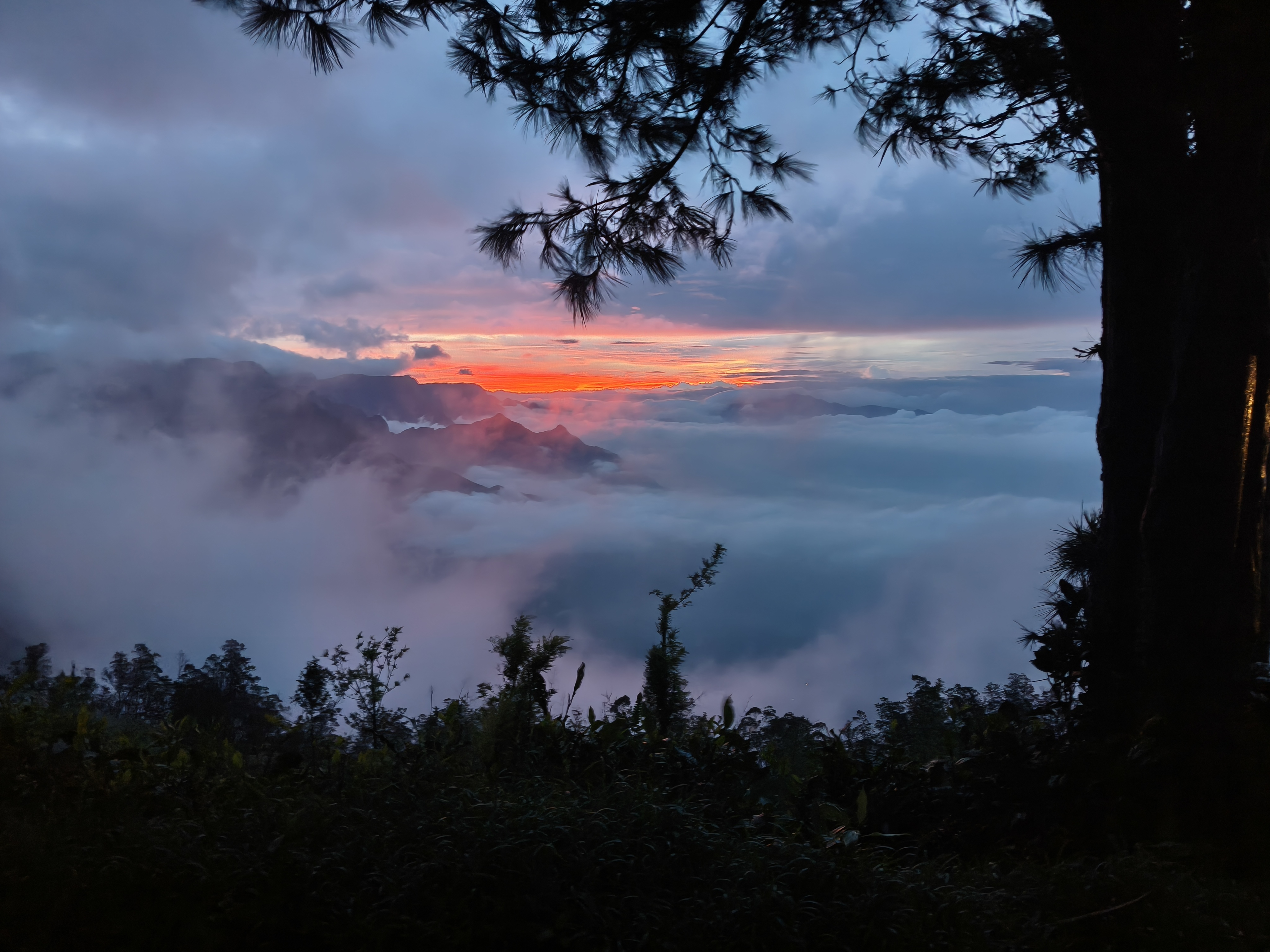 Kolukkumalai sunrise point with jeep overlooking cloud-filled valley in Munnar